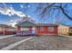 A cozy single-story brick home with a ramp, blue accents, and a well-maintained front yard on a sunny day at 1051 Lima St, Aurora, CO 80010