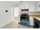 This kitchen features white cabinets, a black range hood, and tile backsplash and flooring at 1051 Lima St, Aurora, CO 80010