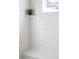 Bathroom featuring white subway tile, a built-in bench, and a plant creating a minimalist and clean aesthetic at 9700 E 63Rd Pl, Denver, CO 80238