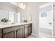 Bathroom showcasing a modern vanity with granite countertop, bright lighting, and a view of the tub creating a serene space at 9700 E 63Rd Pl, Denver, CO 80238