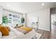 Bright bedroom featuring a large window, stylish decor, and wood-look flooring at 9700 E 63Rd Pl, Denver, CO 80238
