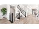 Inviting entryway featuring wood-look floors, wrought iron staircase, and bright, neutral decor showcasing a welcoming atmosphere at 9700 E 63Rd Pl, Denver, CO 80238
