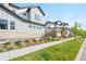 Street view of craftsman style homes with well-manicured landscaping along a sidewalk at 9700 E 63Rd Pl, Denver, CO 80238