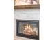 Close-up view of a cozy fireplace with a gray tile surround and decorative mantel at 9700 E 63Rd Pl, Denver, CO 80238