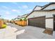 Garage doors of modern homes, accessible from a back alley with wooden privacy fences at 9700 E 63Rd Pl, Denver, CO 80238