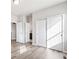 Hallway featuring sliding closet doors, neutral walls, and wood-look floors, with an open bathroom creating an airy feel at 9700 E 63Rd Pl, Denver, CO 80238