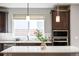 Modern kitchen featuring dark wood cabinets, stainless steel appliances, and a center island at 9700 E 63Rd Pl, Denver, CO 80238