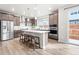 Well-lit kitchen with stainless steel appliances, a large island, and a door to the backyard at 9700 E 63Rd Pl, Denver, CO 80238