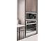 Stainless steel built in oven and microwave with dark brown cabinetry at 9700 E 63Rd Pl, Denver, CO 80238
