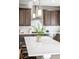 Stylish kitchen island with pendant lighting, quartz countertops, and sleek stainless steel appliances at 9700 E 63Rd Pl, Denver, CO 80238