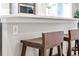 Close up on kitchen island with white countertop and wooden bar stools at 9700 E 63Rd Pl, Denver, CO 80238