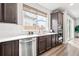 Modern kitchen with stainless steel dishwasher and microwave/oven featuring quartz counters and dark cabinets at 9700 E 63Rd Pl, Denver, CO 80238