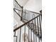 Close up on staircase with rod iron railing and neutral carpet treads at 9700 E 63Rd Pl, Denver, CO 80238