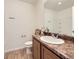 Bathroom with wood cabinets, laminate floors, and modern fixtures at 18241 E 47Th Dr, Denver, CO 80249