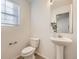 Clean half-bathroom with modern fixtures, pedestal sink, and neutral decor at 18241 E 47Th Dr, Denver, CO 80249