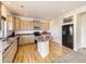 Well-lit kitchen features granite counters, center island, stainless appliances, and wood floors at 18241 E 47Th Dr, Denver, CO 80249