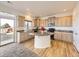 Well-lit kitchen features granite counters, center island, stainless appliances, and wood floors at 18241 E 47Th Dr, Denver, CO 80249