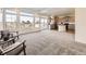 Sunlit living room with large windows and an adjacent kitchen area at 18241 E 47Th Dr, Denver, CO 80249