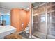 Cozy bathroom features tiled walk-in shower, toilet, vanity and orange walls at 1929 Baguette Dr, Castle Rock, CO 80108