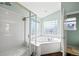 Bright bathroom with soaking tub surrounded by glass block window and walk-in shower at 1929 Baguette Dr, Castle Rock, CO 80108