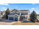 Beautiful two-story home with a three-car garage, a quaint porch and mature trees in a well manicured yard at 1929 Baguette Dr, Castle Rock, CO 80108