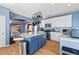 Charming kitchen with stainless steel appliances, granite countertops, blue kitchen island, and hardwood floors at 1929 Baguette Dr, Castle Rock, CO 80108