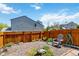 Landscaped backyard with a privacy fence, gravel, and a comfortable chair perfect for outdoor relaxation at 9155 W Portland Ave, Littleton, CO 80128