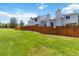 Spacious backyard featuring a lush green lawn, a wooden fence, and well-maintained landscaping at 9155 W Portland Ave, Littleton, CO 80128