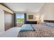 Bedroom with a large window providing a view, a dark wood dresser, and an inviting bed with blue accents at 9155 W Portland Ave, Littleton, CO 80128