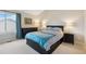 Comfortable bedroom with a dark wood bed frame, a blue blanket, and a window with natural light at 9155 W Portland Ave, Littleton, CO 80128