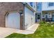 Garage with brick accent with home number, landscaped yard, and covered porch at 9155 W Portland Ave, Littleton, CO 80128