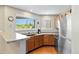 Well-lit kitchen with modern appliances, wood cabinets, and a scenic view from the window at 9155 W Portland Ave, Littleton, CO 80128