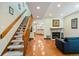 Open-concept living room with a fireplace, wood floors, and a staircase leading to the upper level at 9155 W Portland Ave, Littleton, CO 80128