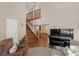 Living room with hardwood floors, staircase, and piano at 16057 Ledge Rock Dr, Parker, CO 80134