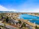 Aerial view of a neighborhood bordering a large lake surrounded by lush greenery, showcasing scenic beauty at 2000 Willow Ln, Lakewood, CO 80215