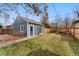 Charming outbuilding in the backyard with a gray exterior and green lawn at 1034 S Williams St, Denver, CO 80209