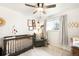 Cozy Bedroom with crib, comfortable chair, decorative items, and a window offering natural light at 10618 W Layton Pl, Littleton, CO 80127