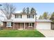 Charming two-story home with brick and white siding, manicured lawn, and attached two-car garage at 10618 W Layton Pl, Littleton, CO 80127