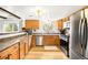 Functional kitchen with stainless steel appliances, oak cabinets, and ample counter space at 10618 W Layton Pl, Littleton, CO 80127