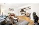 Open-concept living room with a fireplace, hardwood floors, and comfortable seating at 10618 W Layton Pl, Littleton, CO 80127