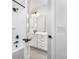 Bright bathroom with a shower/tub combo, modern fixtures, white tiles, and modern hardware, promoting a clean aesthetic at 8864 Moonshimmer Trl, Littleton, CO 80125