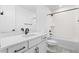 Bathroom featuring a sleek white vanity with black hardware, a toilet and shower-tub combo at 8864 Moonshimmer Trl, Littleton, CO 80125