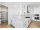 White kitchen featuring a large pantry, white subway tile backsplash, quartz countertops, and stainless steel appliances at 8864 Moonshimmer Trl, Littleton, CO 80125