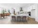 Bright kitchen featuring white cabinets, a large center island with bar stools, and modern appliances at 8864 Moonshimmer Trl, Littleton, CO 80125