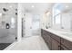 Main bathroom featuring double vanity, large mirror, and glass enclosed shower at 8864 Moonshimmer Trl, Littleton, CO 80125