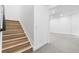 Bright staircase features light wood stairs, white walls, and flows into adjacent room at 8864 Moonshimmer Trl, Littleton, CO 80125