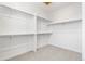 Walk-in closet with white shelving, hanging racks, and carpet floors at 8864 Moonshimmer Trl, Littleton, CO 80125