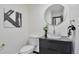 Modern half bath with unique vessel sink, patterned accent wall, black vanity with diamond pattern, and gold fixtures at 4853 S Crystal St, Aurora, CO 80015