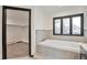 Bright bathroom featuring a soaking tub with modern fixtures and a walk-in closet at 4853 S Crystal St, Aurora, CO 80015