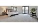 Spacious bedroom with carpet, a decorative chair, and doors to an outdoor balcony at 4853 S Crystal St, Aurora, CO 80015
